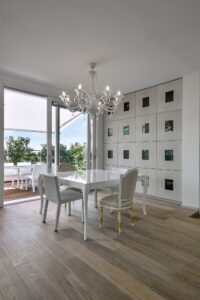 Modern Dining Table in a Living Room with Old Chandelier overlooking on the Terrace