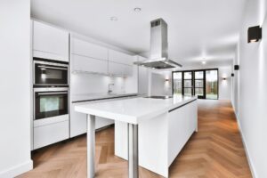 Modern kitchen design with white kitchen set and parquet floor