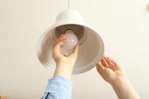 Replacing the light bulb in the chandelier in the kitchen