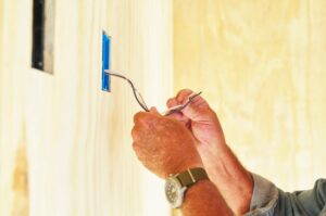 Senior man working on electrical wiring in a house.